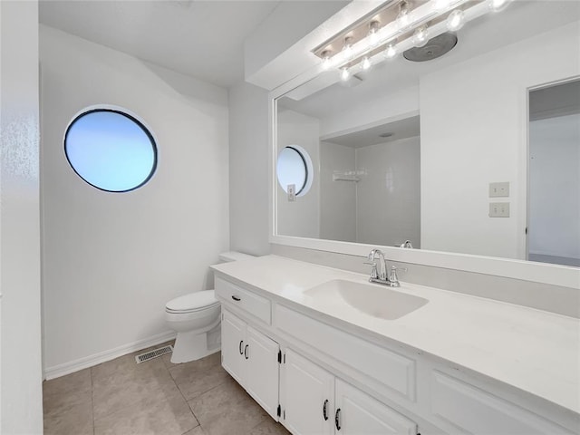 bathroom featuring vanity, tile patterned floors, and toilet