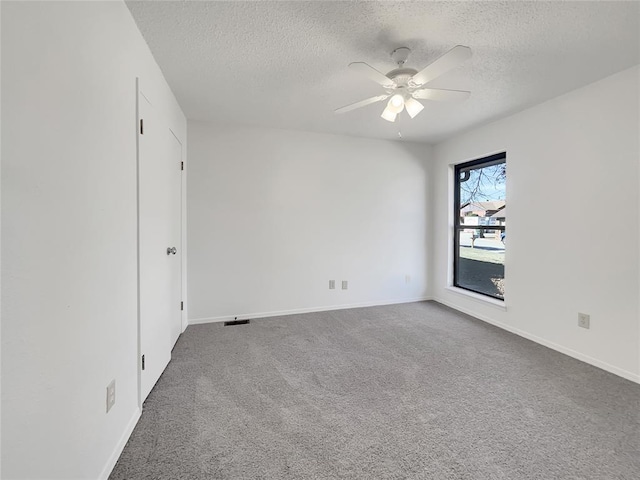 spare room featuring ceiling fan, carpet floors, and a textured ceiling