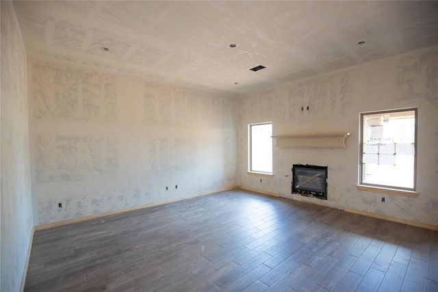 9225 NW 86th St, Yukon, OK 73099 - unfurnished living room featuring wood finished floors and a glass covered fireplace