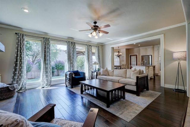 living room featuring a healthy amount of sunlight, ornamental molding, dark hardwood / wood-style flooring, and ceiling fan with notable chandelier