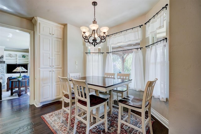 dining area featuring dark wood-type flooring and an inviting chandelier