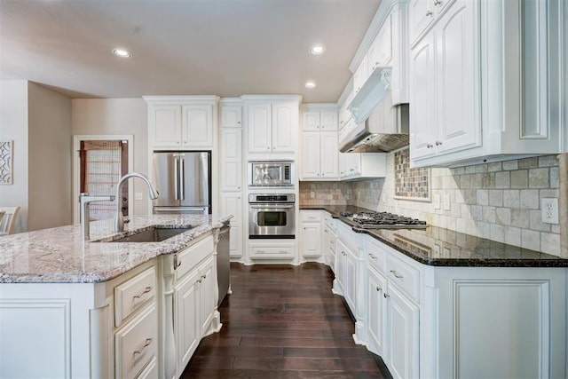 kitchen with white cabinetry, appliances with stainless steel finishes, stone countertops, and sink