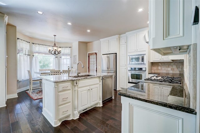 kitchen with stainless steel appliances, a center island with sink, and white cabinets