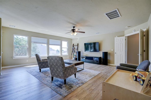 living room with ceiling fan and light wood-type flooring