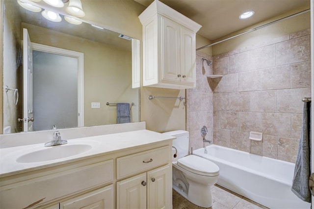 full bathroom featuring tiled shower / bath combo, vanity, tile patterned floors, and toilet