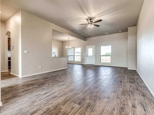 unfurnished room with ceiling fan with notable chandelier and dark hardwood / wood-style floors