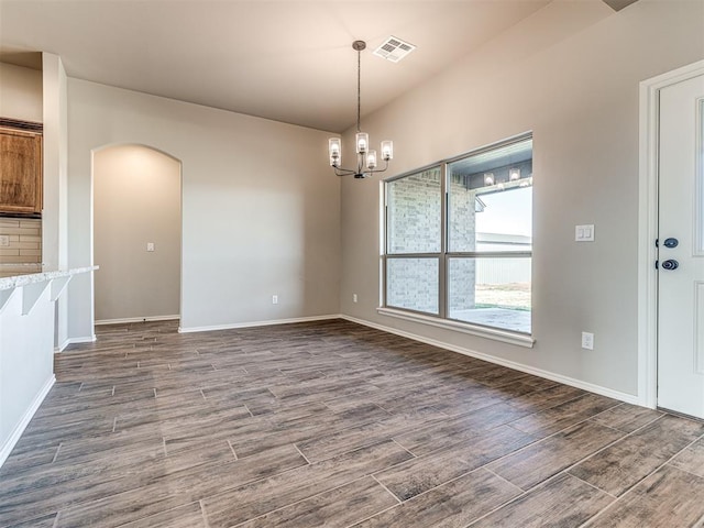 unfurnished dining area with dark wood-type flooring and a chandelier