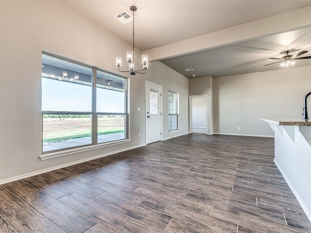 unfurnished dining area featuring ceiling fan with notable chandelier and dark hardwood / wood-style floors