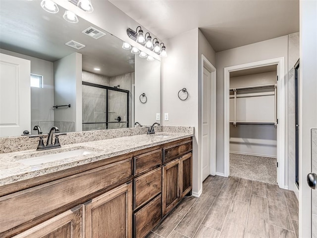 bathroom with vanity and a shower with shower door