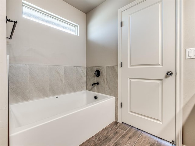 bathroom featuring hardwood / wood-style flooring and a bath