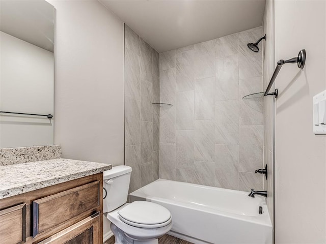 full bathroom featuring vanity, tiled shower / bath combo, and toilet