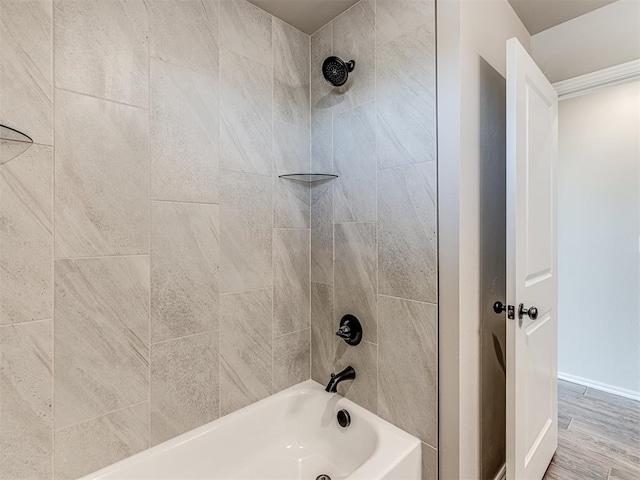 bathroom with hardwood / wood-style flooring and tiled shower / bath combo