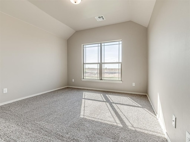 spare room with vaulted ceiling and carpet