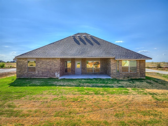 rear view of house with a lawn and a patio