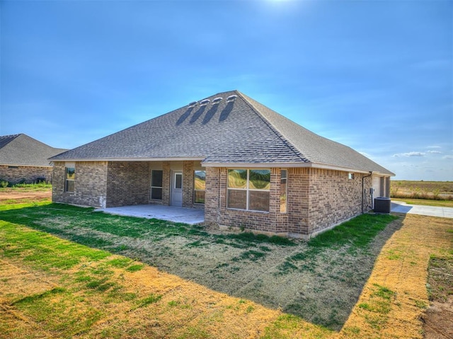 rear view of house with cooling unit, a lawn, and a patio area