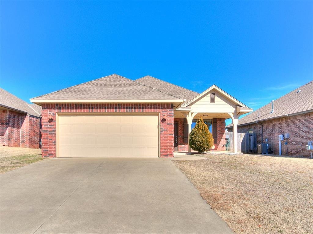 view of front of house featuring a garage and central air condition unit