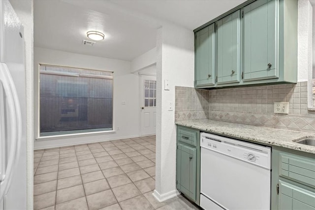 kitchen with white appliances, light stone countertops, decorative backsplash, and green cabinetry