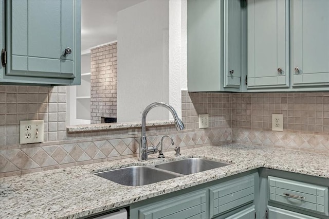 kitchen featuring sink, light stone counters, and decorative backsplash