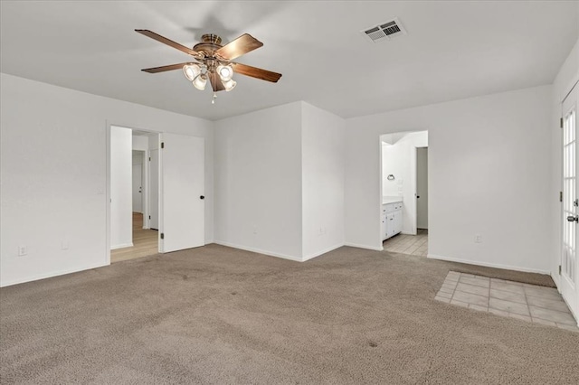 carpeted spare room featuring ceiling fan