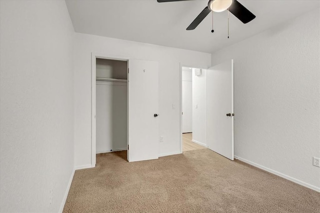 unfurnished bedroom featuring light colored carpet, ceiling fan, and a closet