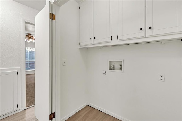 laundry area with hookup for a washing machine, light hardwood / wood-style flooring, and cabinets