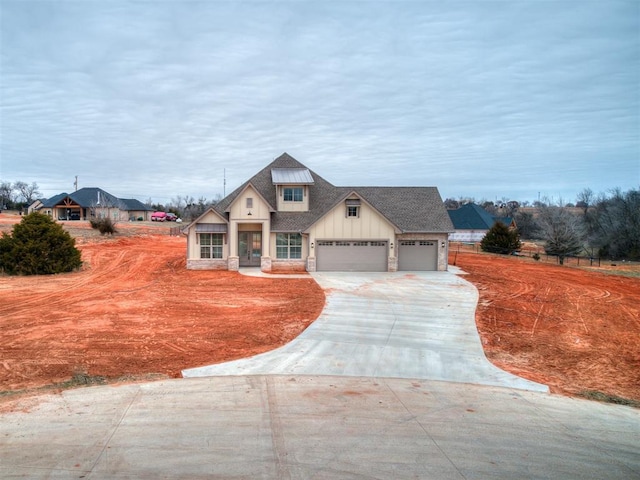 view of front of home featuring stone siding, board and batten siding, concrete driveway, a shingled roof, and a garage