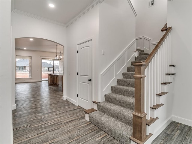 stairs with crown molding and hardwood / wood-style flooring