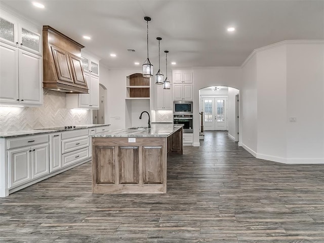 kitchen featuring white cabinetry and an island with sink