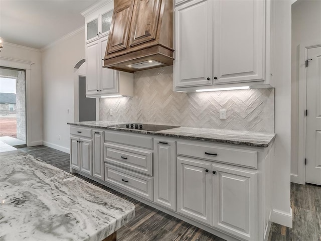 kitchen featuring premium range hood, white cabinets, dark hardwood / wood-style flooring, crown molding, and black electric cooktop