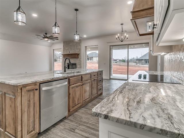 kitchen featuring stainless steel dishwasher, a large island, sink, and hanging light fixtures