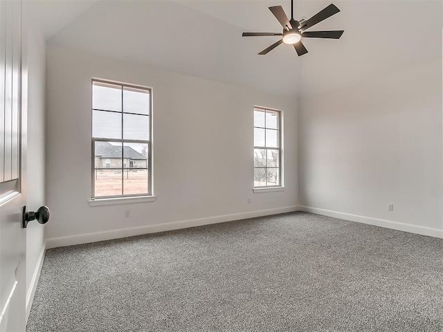 empty room featuring vaulted ceiling, ceiling fan, and carpet flooring