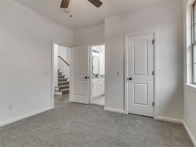 unfurnished bedroom with ensuite bathroom and light carpet