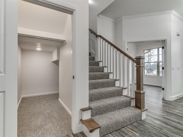 stairs featuring hardwood / wood-style flooring and ornamental molding