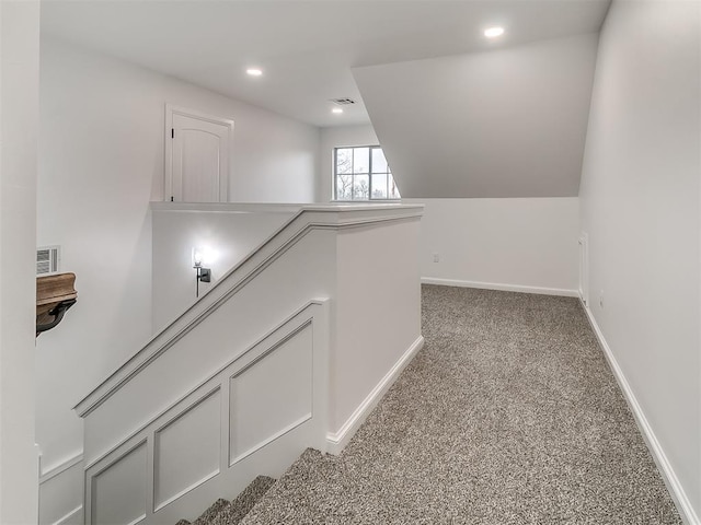 hall featuring light colored carpet and lofted ceiling