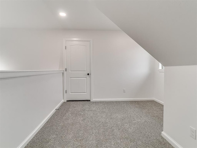 additional living space featuring vaulted ceiling and carpet