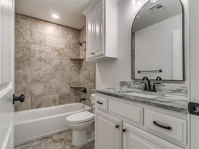 full bathroom featuring vanity, tiled shower / bath combo, and toilet