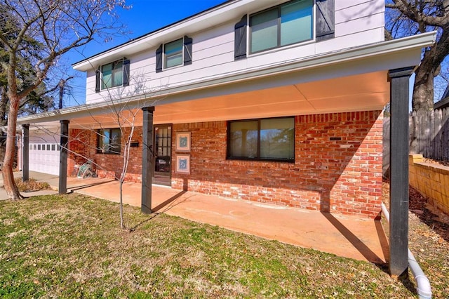 rear view of property with a garage and a lawn