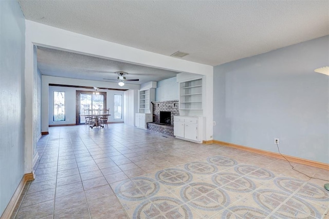 unfurnished living room with a brick fireplace, light tile patterned floors, a textured ceiling, built in features, and ceiling fan