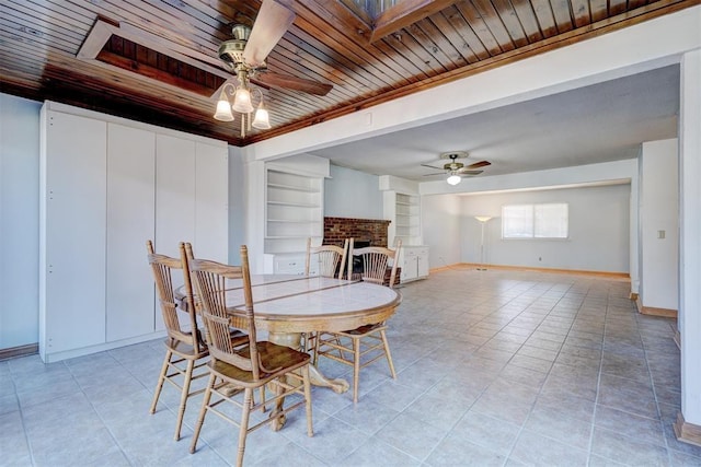 tiled dining area with ceiling fan, built in features, a fireplace, and wood ceiling