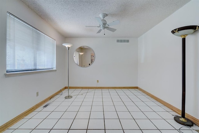 unfurnished room featuring light tile patterned floors, a textured ceiling, and ceiling fan