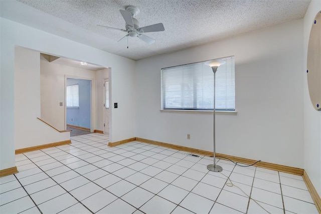 spare room with a textured ceiling and ceiling fan