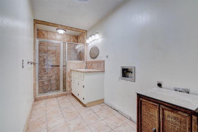 bathroom with tile patterned floors, vanity, and a shower with door