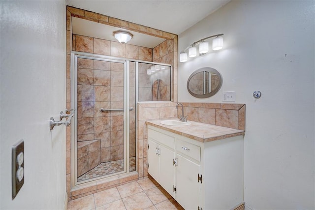 bathroom with vanity, tile patterned floors, a shower with door, and decorative backsplash