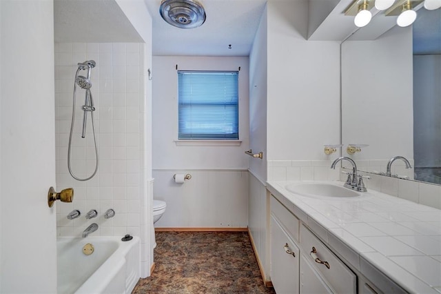 full bathroom with tiled shower / bath, vanity, and toilet