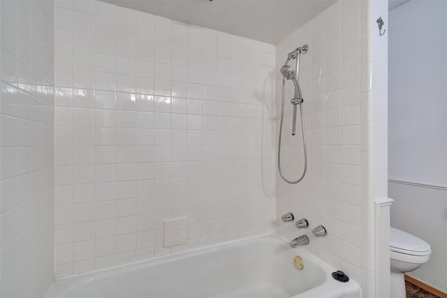 bathroom with toilet and tiled shower / bath combo