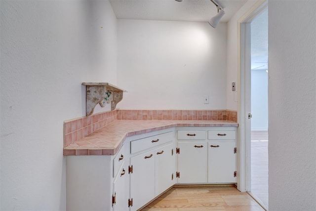 kitchen with white cabinetry and light hardwood / wood-style flooring