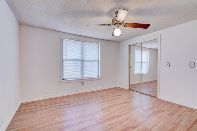 empty room featuring ceiling fan, light hardwood / wood-style flooring, and a textured ceiling