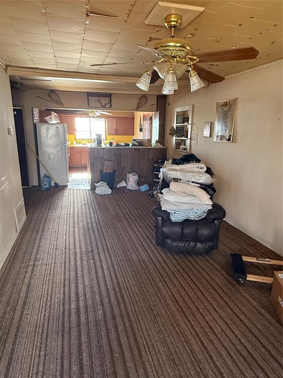 miscellaneous room featuring ceiling fan and dark carpet