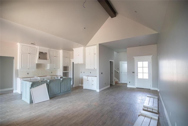8116 NW 152nd Ter, Edmond, OK 73013 - kitchen with high vaulted ceiling, beamed ceiling, white cabinets, a kitchen island, and light wood-style flooring