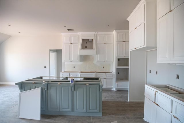 8116 NW 152nd Ter, Edmond, OK 73013 - kitchen featuring a center island, white cabinetry, custom exhaust hood, wood finished floors, and vaulted ceiling